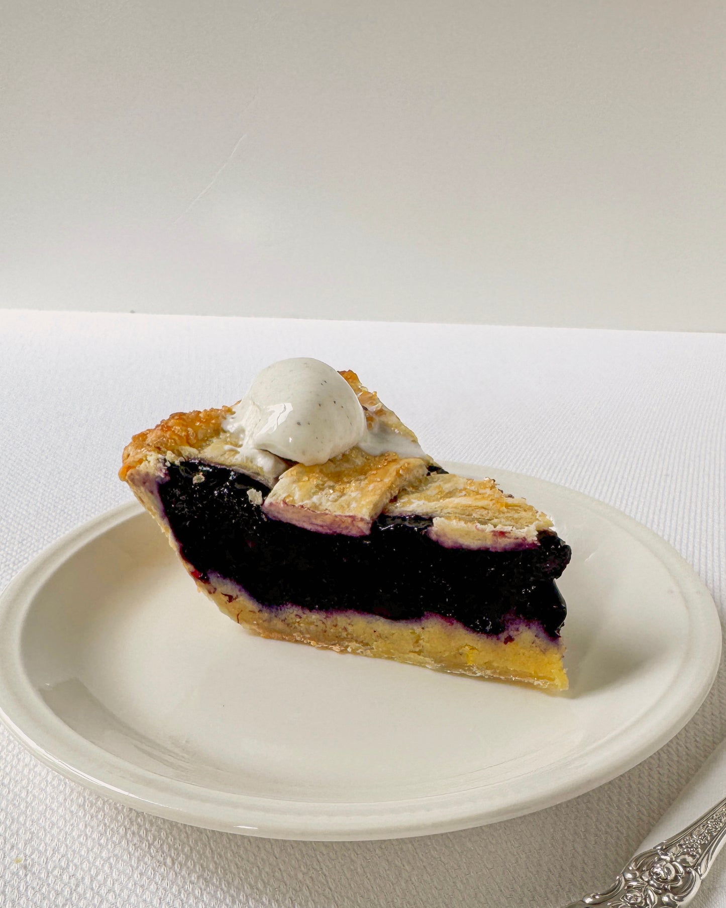 Slice of blueberry lemon frangipane pie showing almond frangipane texture and fresh blueberry filling