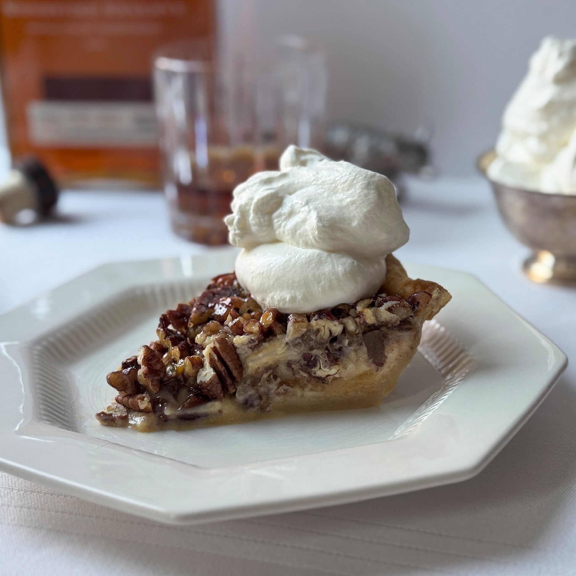 Pecan pie slice with whipped cream and warm bourbon notes baked by Sunday Crust Augusta Georgia