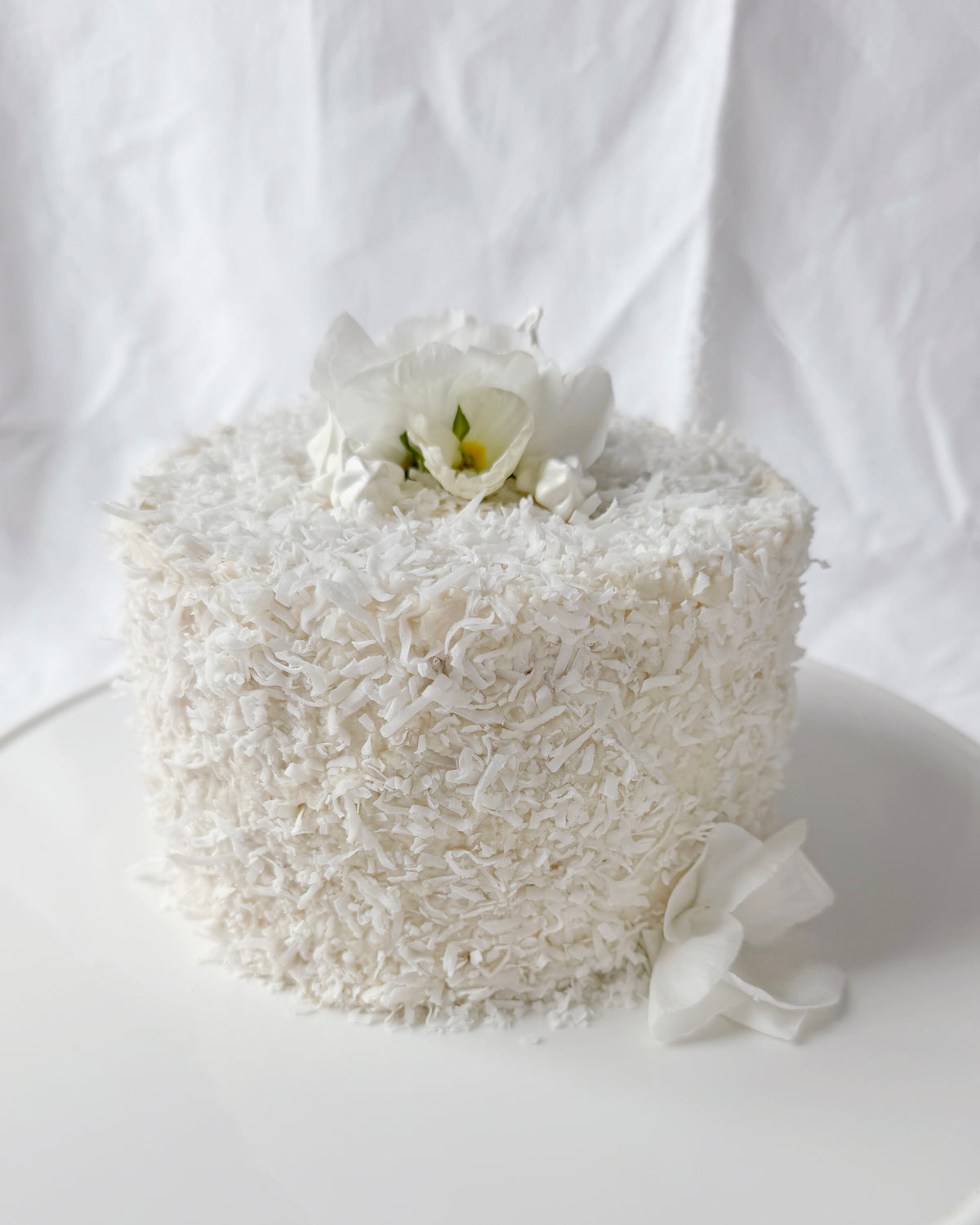 Coconut cake decorated with seasonal spring flowers in Savannah GA