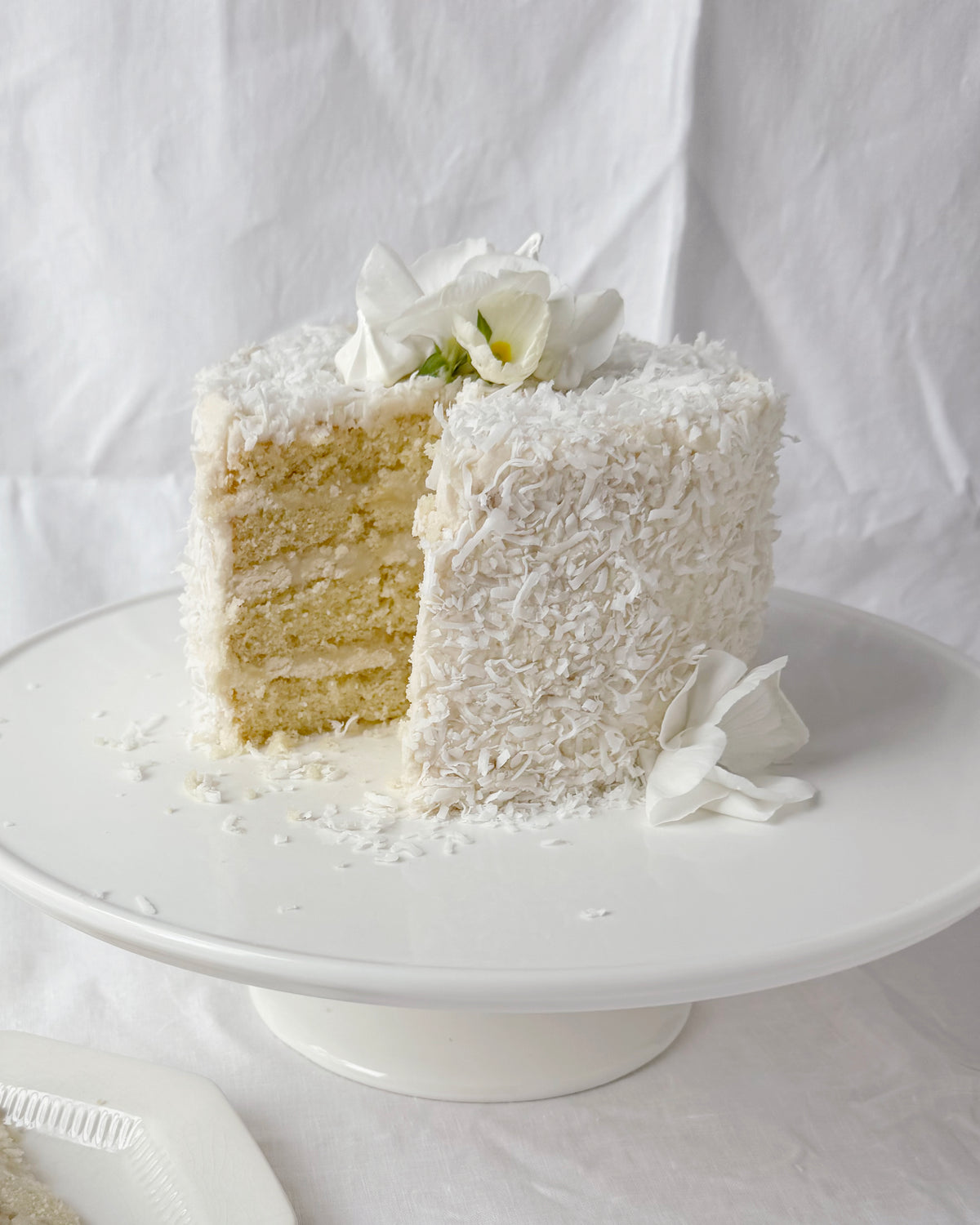 Four layer coconut garden cake with haupia coconut cream and seasonal spring flowers in Savannah Georgia