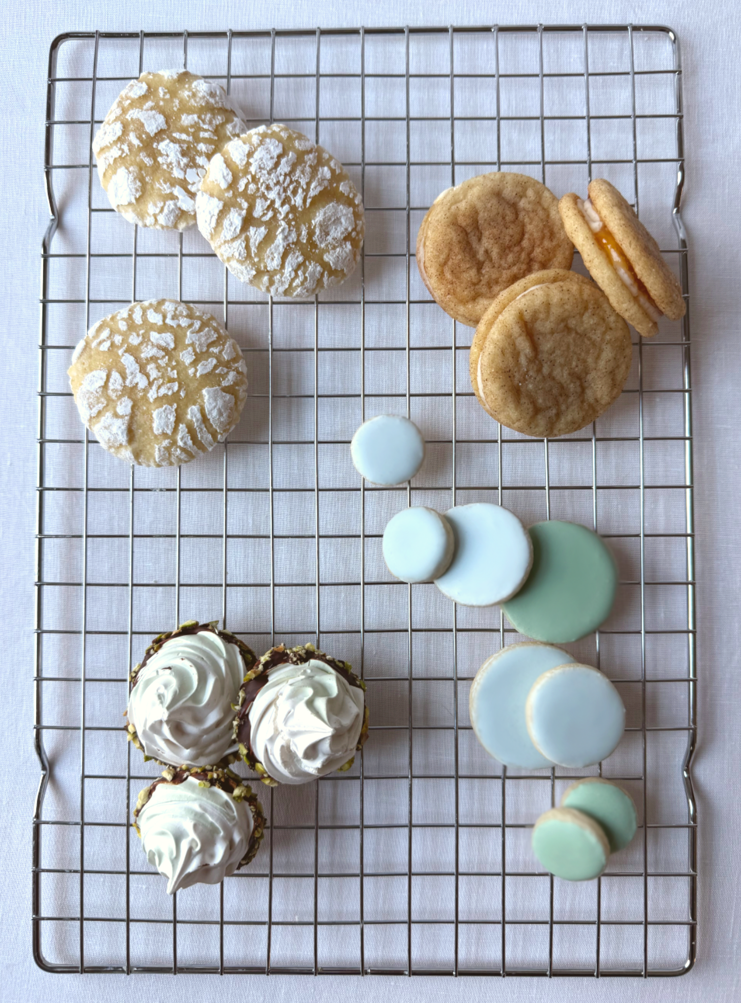 Tastemaker rounds and assorted spring cookies on cooling rack in soft pastel colors