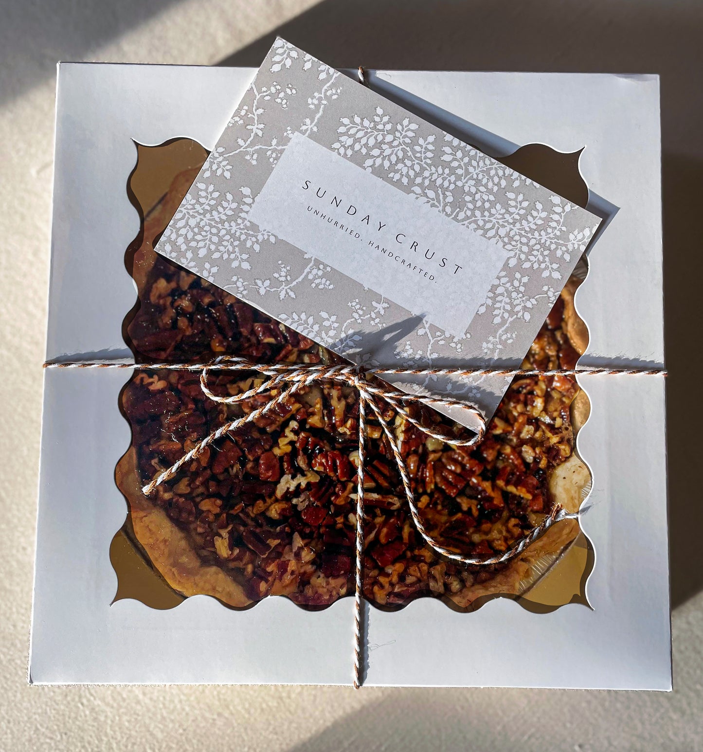 Pecan pie packaged for gifting with Sunday Crust card and ribbon baked in Augusta Georgia